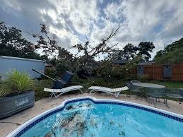 Image of a Florida backyard pool under storm clouds. - FloridaDetail.Com